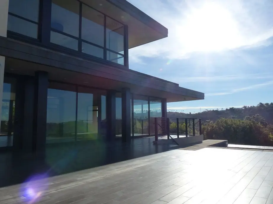 Upstairs interior of a modern San Diego hillside home with dark aluminum-framed glass overlooking the coastal view, a real Builder's Window Supply install.