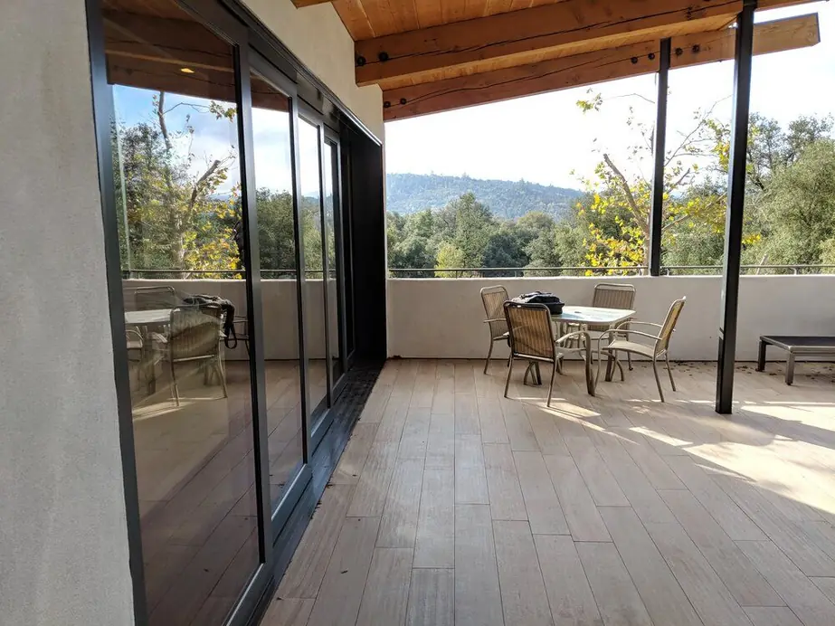 A brick-and-timber contemporary home exterior with a wood clad window and door installation, a real Builder's Window Supply delivery.