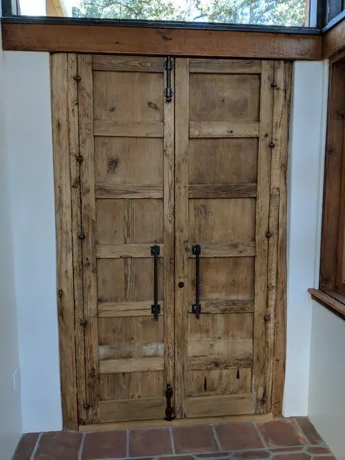 A walnut sliding door opening onto a wardrobe beyond, a real Builder's Window Supply delivery.
